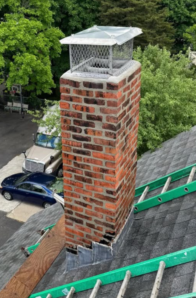 Aerial view of a tall brick chimney with a new stainless cap