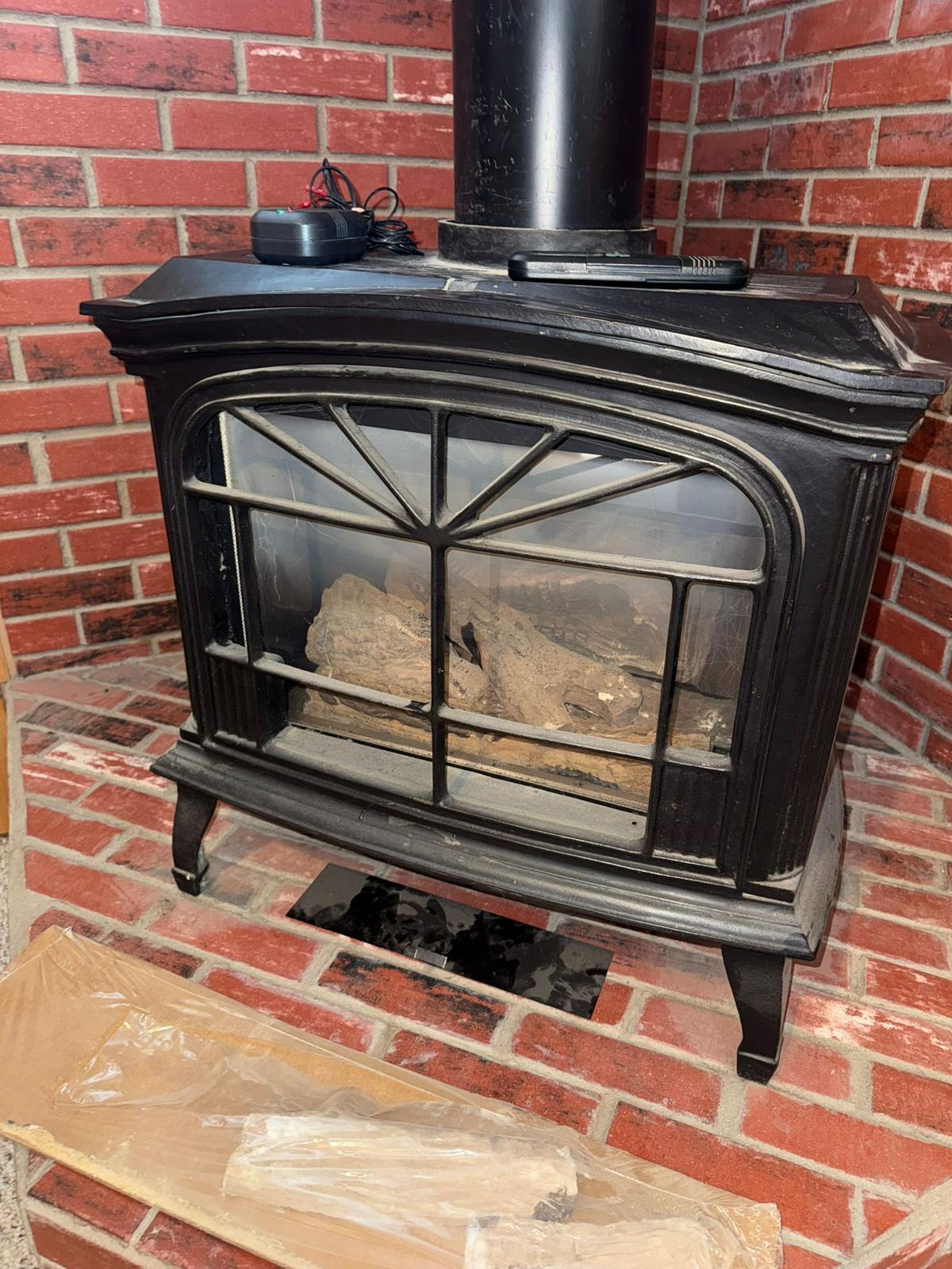Cast iron fireplace stove on a brick hearth serviced in Cincinnati