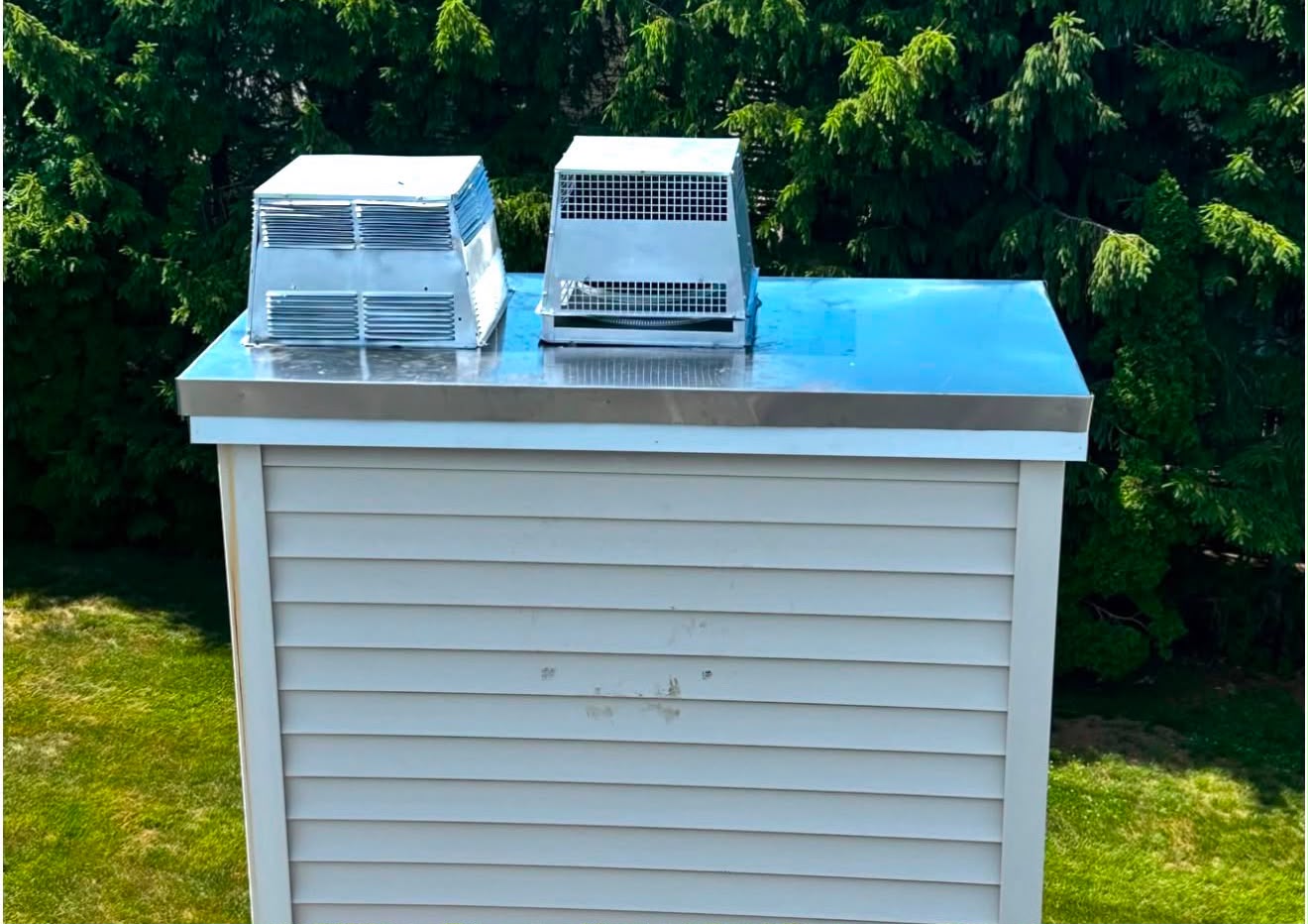 New stainless chase cover with two caps on a sided chimney chase