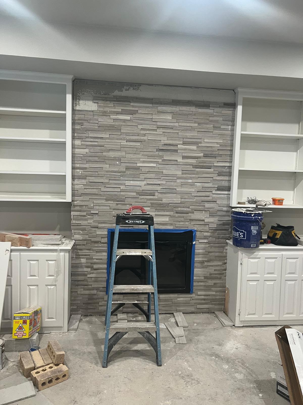 Interior fireplace with new stacked stone surround under construction